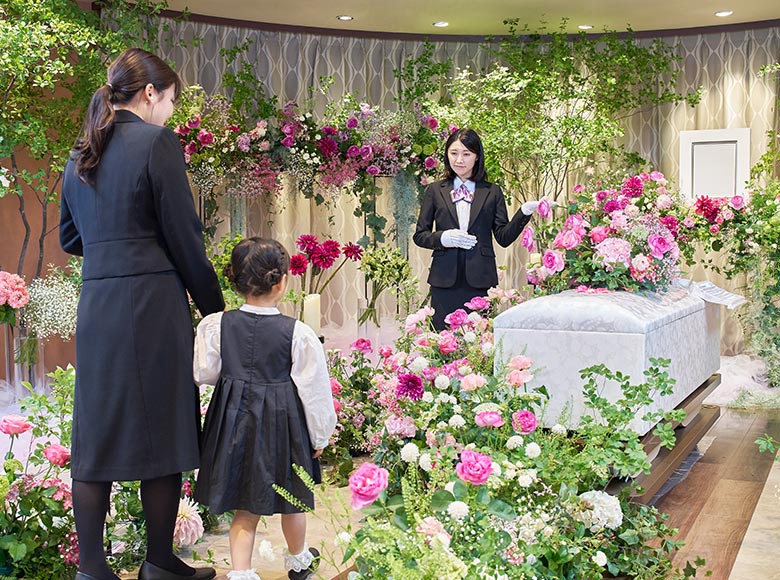 家族葬の様子。棺の周りには白やピンクなどたくさんの花が飾られています。