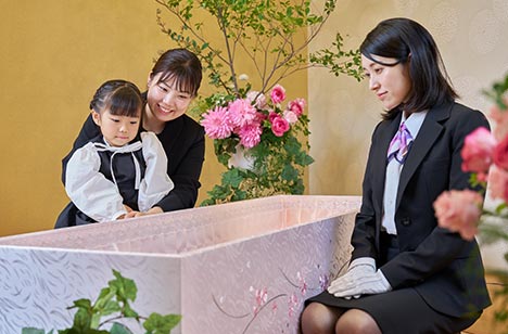都典礼世田谷店の葬儀スタッフとご遺族が棺を見ています